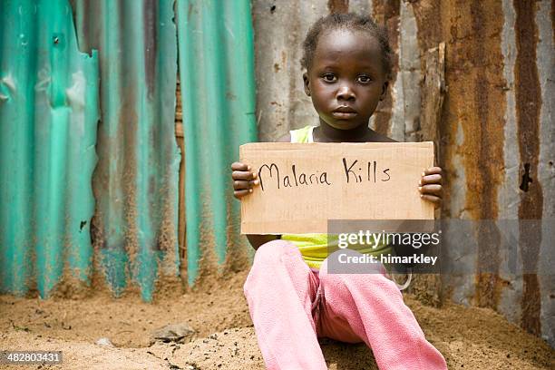 african girl holding sign with "malaria kills" written on it - malaria stock pictures, royalty-free photos & images