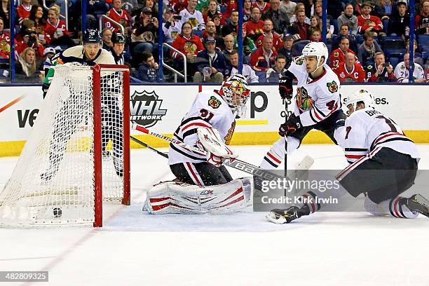 Artem Ansimov of the Columbus Blue Jackets gets the puck past Antti Raanta, Niklas Hjalmarsson and Brent Seabrook of the Chicago Blackhawks fall on a...