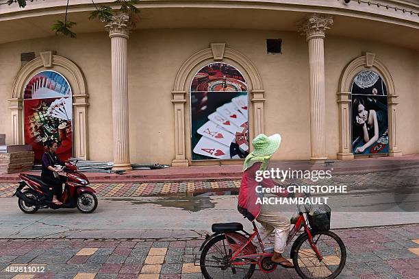 By Marion THIBAUT This picture taken on April 9, 2015 shows an employee riding a scooter past the Kings Romans Chinese-owned casino in Ton Pheung, a...