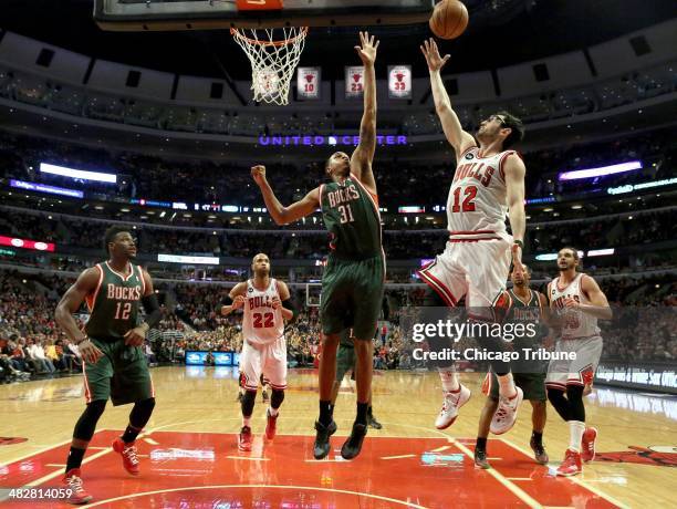 Chicago Bulls guard Kirk Hinrich tries to score on a layup against Milwaukee Bucks center John Henson in the first half at the United Center in...