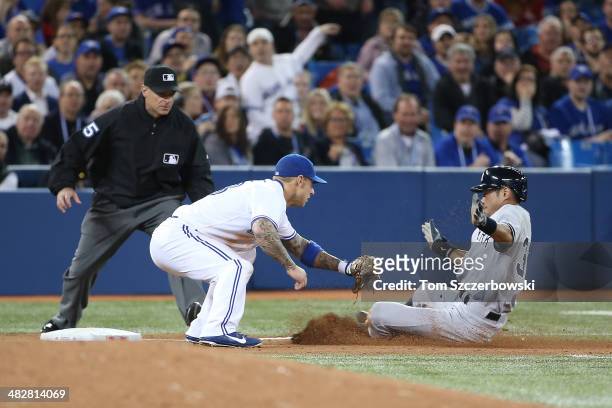 Ichiro Suzuki of the New York Yankees is tagged out in the fifth inning during MLB game action by Brett lawrie of Toronto Blue Jays on April 4, 2014...