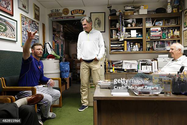 Josh Donaldson of the Toronto Blue Jays talks with General Manager Billy Beane and Equipment Manager Steve Vucinich in the Athletics clubhouse prior...