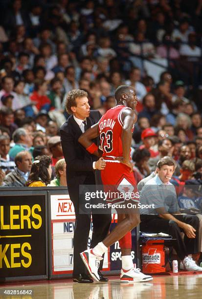 Head coach Doug Collins of the Chicago Bulls talks with his player Michael Jordan against the Washington Bullets during an NBA basketball game circa...