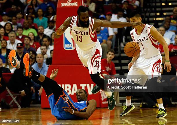 James Harden of the Houston Rockets trips over Kevin Durant of the Oklahoma City Thunder in the second period during a game at the Toyota Center on...