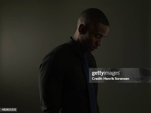 portrait of a black man on a dark background - studio portrait dark background stock-fotos und bilder