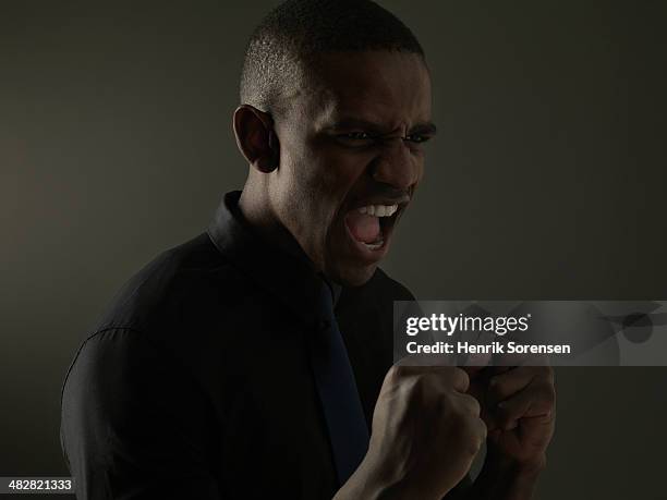 portrait of a black man on a dark background - anger fist stock pictures, royalty-free photos & images