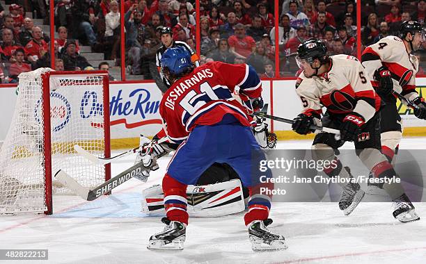 David Desharnais of the Montreal Canadiens shoots the puck for a goal in the third period past Craig Anderson of the Ottawa Senators as Cody Ceci of...