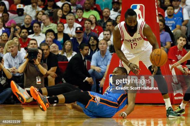 Kevin Durant of the Oklahoma City Thunder falls to the court after fighting for a ball against James Harden of the Houston Rockets in the second...