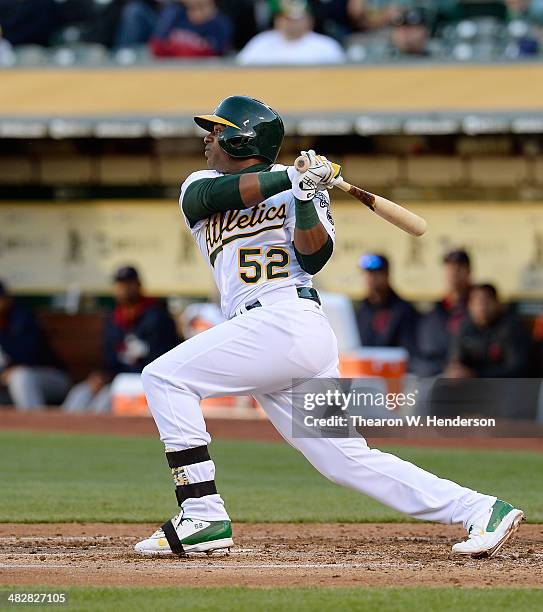 Yoenis Cespedes of the Oakland Athletics hits an RBI double scoring Jed Lowrie against the Cleveland Indians in the bottom of the first inning at...