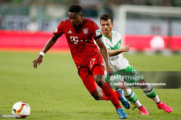 David Alaba of Bayern Muenchen battles for the ball with Vieirinha of VfL Wolfsburg during the DFL Supercup match between VfL Wolfsburg and FC Bayern...