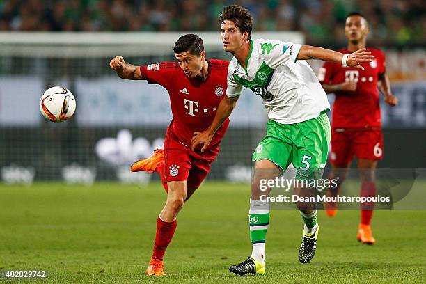 Robert Lewandowski of Bayern Muenchen battles for the ball with Timm Klose of VfL Wolfsburg during the DFL Supercup match between VfL Wolfsburg and...