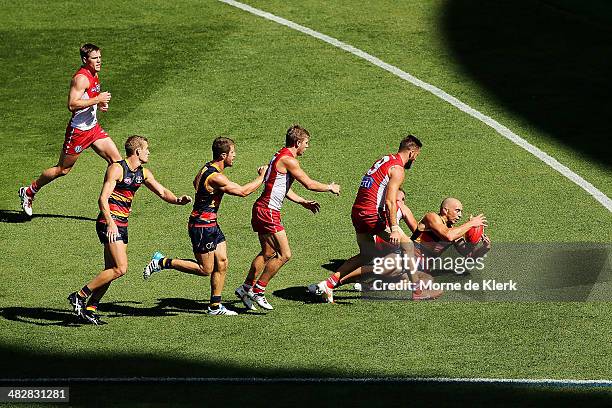 James Podsiadly of Adelaide is tackled during the round three AFL match between the Adelaide Crows and the Sydney Swans at Adelaide Oval on April 5,...