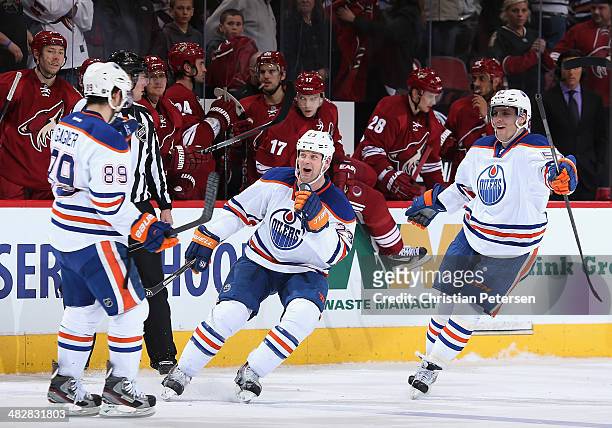 Matt Hendricks and David Perron of the Edmonton Oilers congratulate Sam Gagner after Gagner scored the game winning shoot-out goal against the...