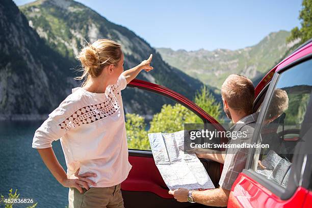 paar touristen mit mietwagen lesen karte-ausflug - auto mieten stock-fotos und bilder