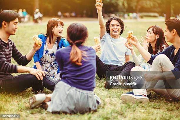 gruppo di giovani popolo giapponese in the park - girls laughing eating sandwich foto e immagini stock