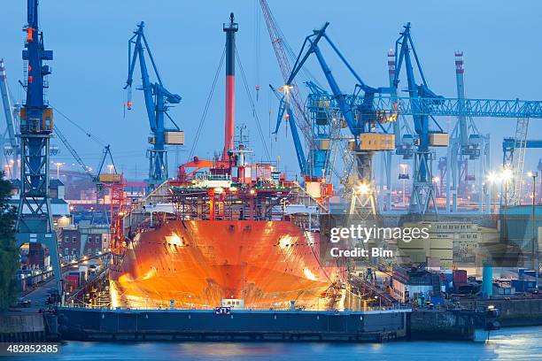 ship maintenance in dry dock at night, hamburg harbor - shipbuilder stock pictures, royalty-free photos & images