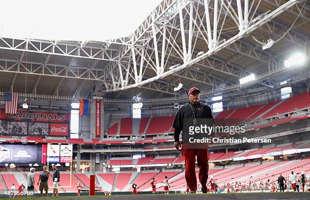 Head coach Bruce Arians of the Arizona Cardinals walks off the field following the team training camp at University of Phoenix Stadium on August 2,...