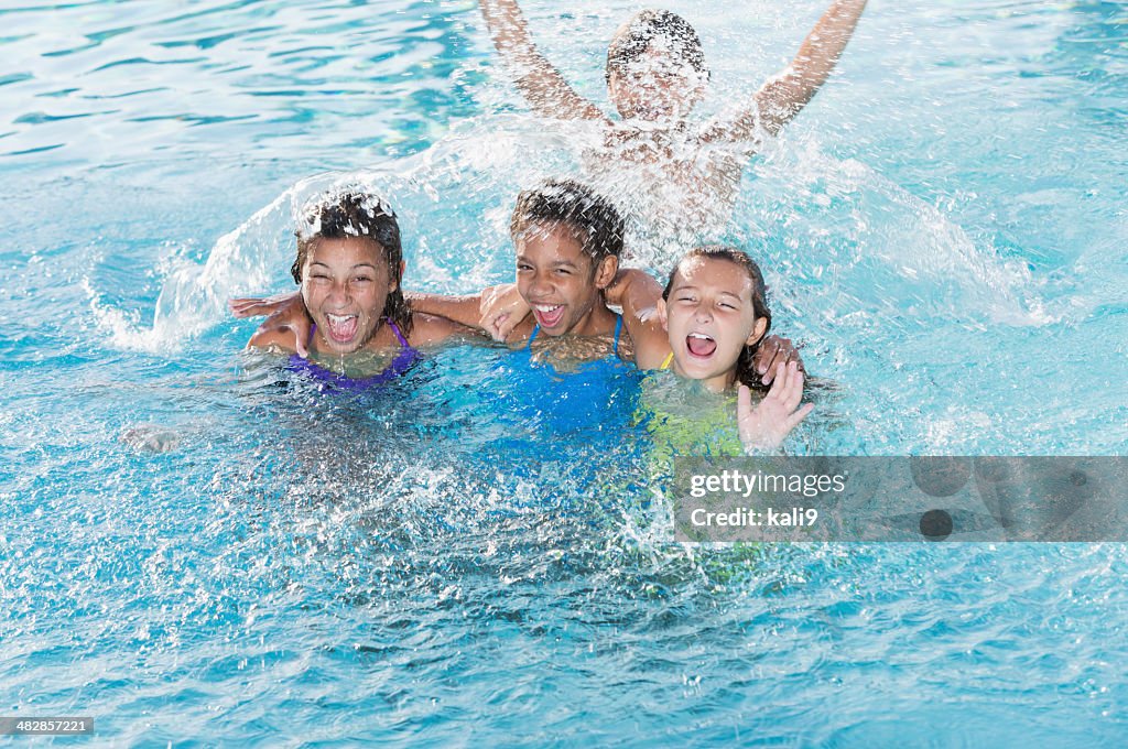 Children splashing in swimming pool.