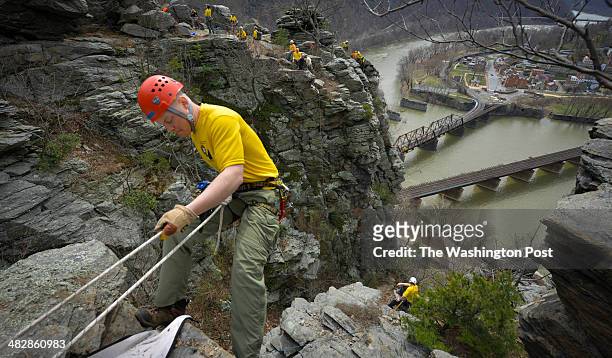 Matt Lippy prepares of descend down a cliff as the National Park Service trains for technical rescue climbing on the Maryland Heights rockface near...