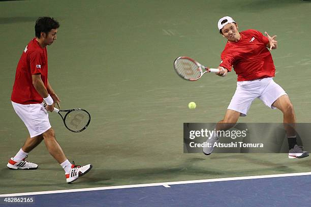 Tatsuma Ito and Yasutaka Uchiyama of Japan in action during their doubles match against Radek Stepanek and Lukas Rosol of Czech Republic during day...