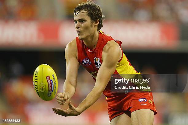 Kade Kolodjashnij of the Suns handballs during the round three AFL match between the Gold Coast Suns and the Brisbane Lions at Metricon Stadium on...