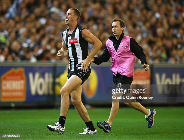 Nick Maxwell of the Magpies is helped from the ground by a trainer during the round three AFL match between the Collingwood Magpies and the Carlton...