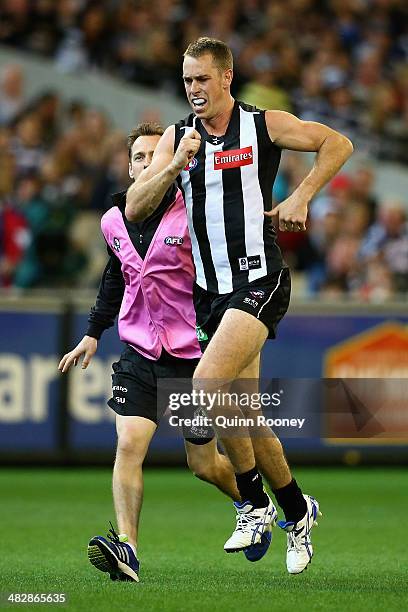 Nick Maxwell of the Magpies is helped from the ground by a trainer during the round three AFL match between the Collingwood Magpies and the Carlton...