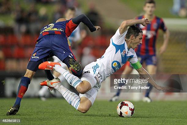 Mark Milligan of the Victory is tackled by Ruben Zadkovich of the Jets during the round 26 A-League match between the Newcastle Jets and Melbourne...
