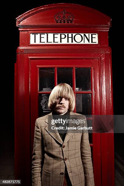 mod in front of a red telephone box - telephone booth stockfoto's en -beelden