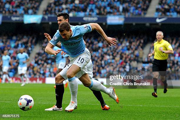 Edin Dzeko of Manchester City wins a penalty as he is brought down by Jose Fonte of Southampton under the watchful eye of Referee Chris Foy during...