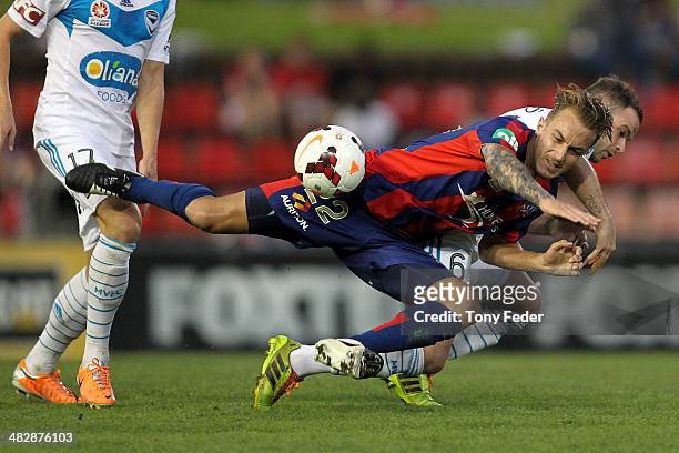 Adam Taggart of the Jets contests the ball with Leigh Broxham of the Victory during the round 26 A-League match between the Newcastle Jets and...