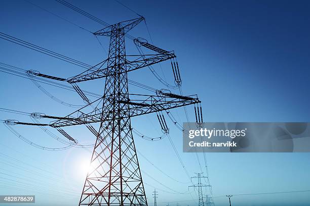 power lines und rising sun - hochspannungsmast stock-fotos und bilder