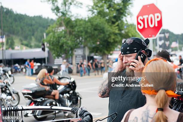 Rell Carver, Jr. Tries to hear a phone conversation above the roar of passing motorcycles downtown on the first day of the annual Sturgis Motorcycle...