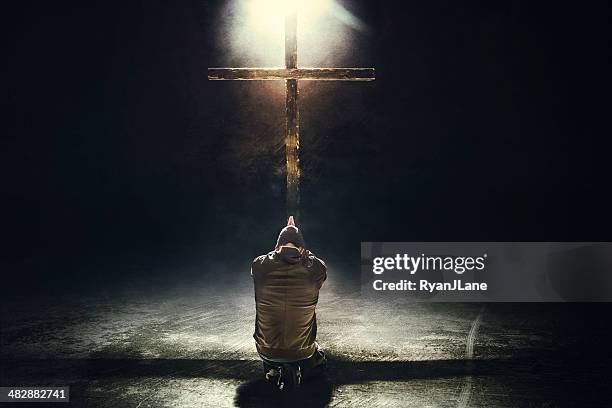mann kniend vor dem cross - jesus christ fotos stock-fotos und bilder