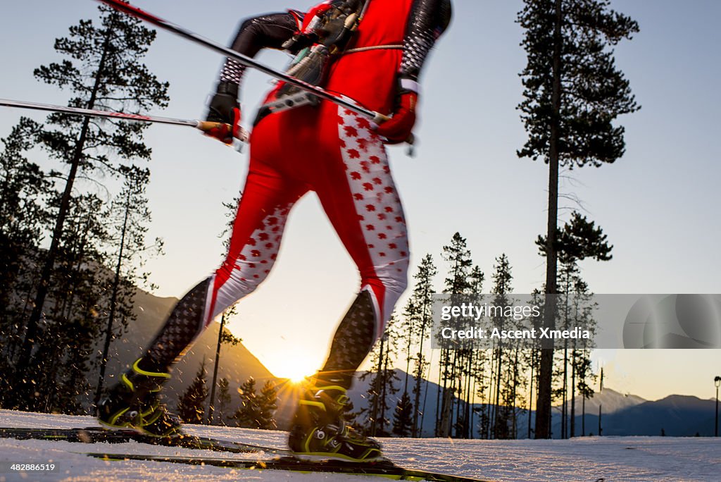 Biathlete trains on mountain trail, in snow