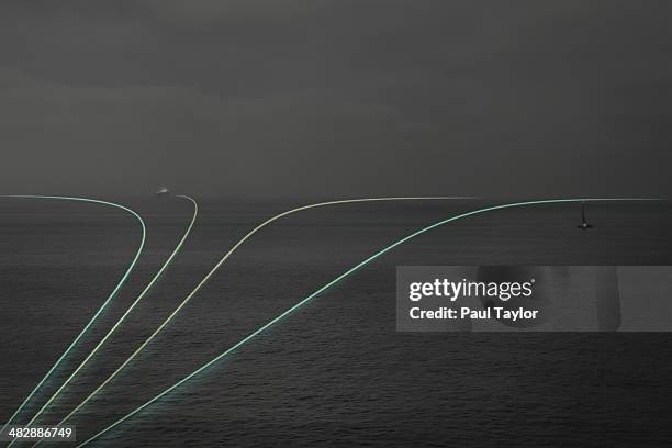 light trails over ocean - entsättigt stock-fotos und bilder