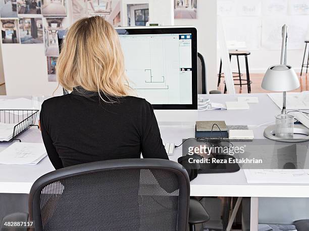 female designer works on computer - office chair stockfoto's en -beelden