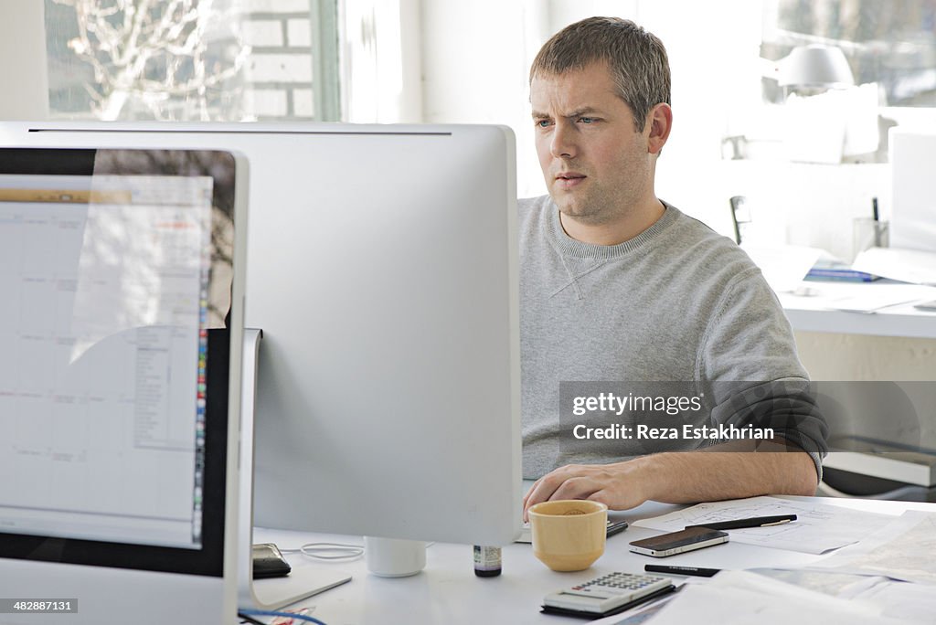 Young designer checks computer information