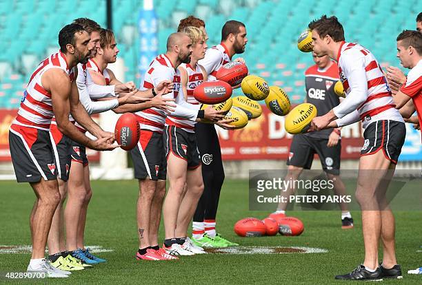 Australian Rules football star and one of Australia's most high-profile indigenous sportsmen Adam Goodes takes with his Sydney Swans teammates during...