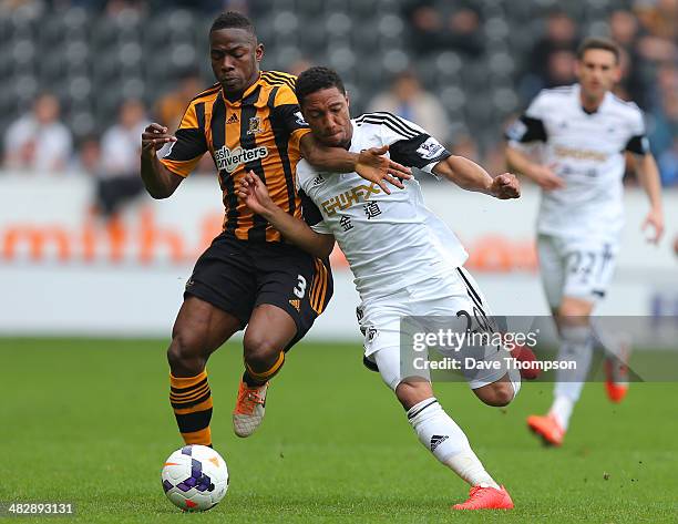 Hull City's Maynor Figueroa and Swansea City's Jonathan de Guzman compete or the ball during the Barclays Premier League match between Hull City and...