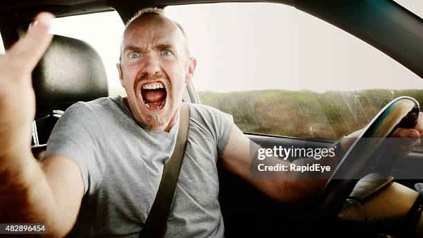 road rage: furious male driver shouting, waving, and yelling - verkeersagressie stockfoto's en -beelden