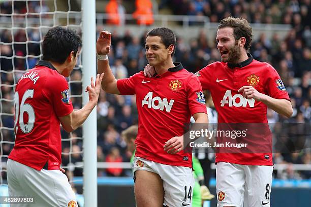 Shinji Kagawa and Juan Mata of Manchester United congratulate Javier Hernandez of Manchester United on scoring their third goal during the Barclays...