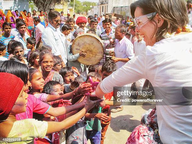 tourist meeting children during holi festival in rural indian village - offspring culture tourism festival stock pictures, royalty-free photos & images