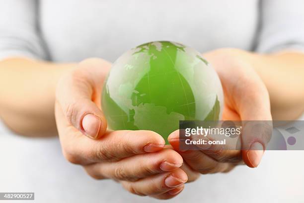 green globe in der hand - responsibility stock-fotos und bilder