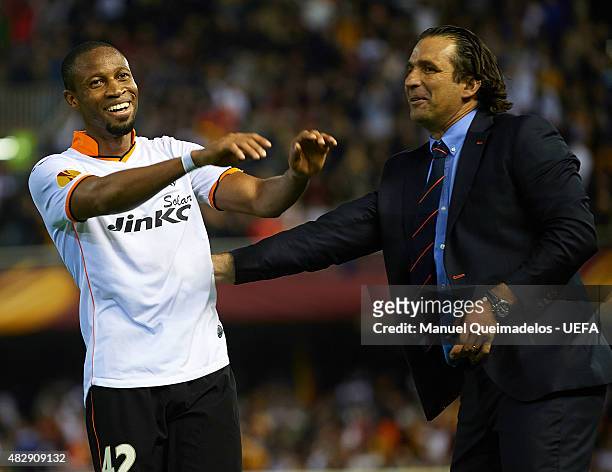 Seydou Keita of Valenica shares a joke with Coach Juan Antonio Pizzi of Valencia during the UEFA Europa League Quarter Final second leg match between...