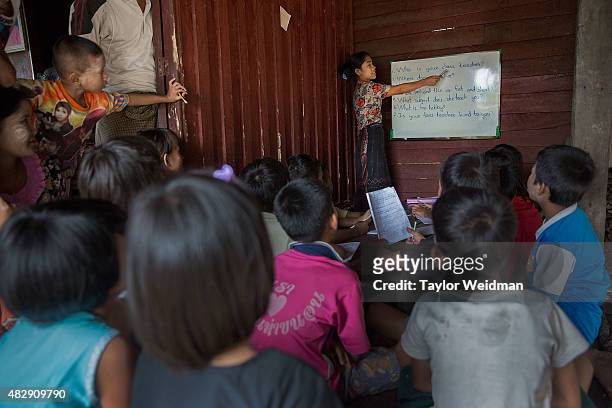 Burmese teacher instructs students in a small classroom in a village near the planned Dawei SEZ on August 2, 2015 in Bawar Village, Myanmar. The...