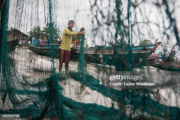 Burmese fisherman works near a boat in his village near the planned Dawei SEZ on August 2, 2015 in Bawar Village, Myanmar. The controversial,...