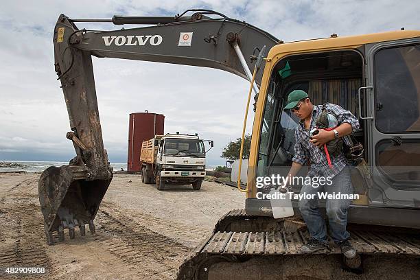 Construction worker dismounts a piece of equipment after working on the construction of a small, interim port inside the planned Dawei SEZ on August...