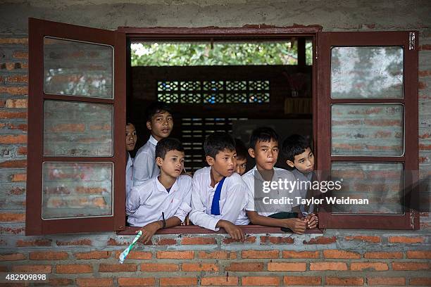 Students look out the window of their classroom in a village inside the planned Dawei SEZ on August 3, 2015 in Mudu, Myanmar. The controversial,...