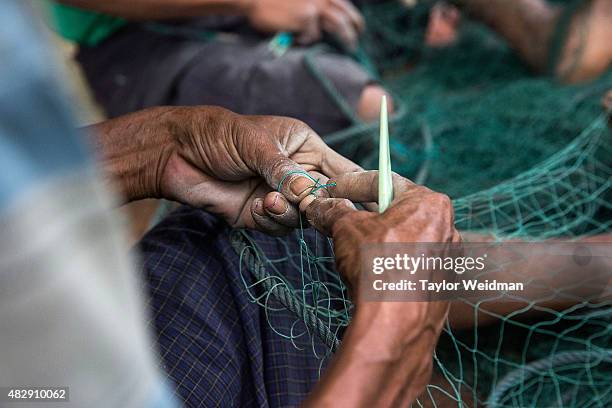 Burmese fishermen mend nets in their village near the planned Dawei SEZ on August 4, 2015 in Pantininn, Myanmar. The controversial, multi-billion...